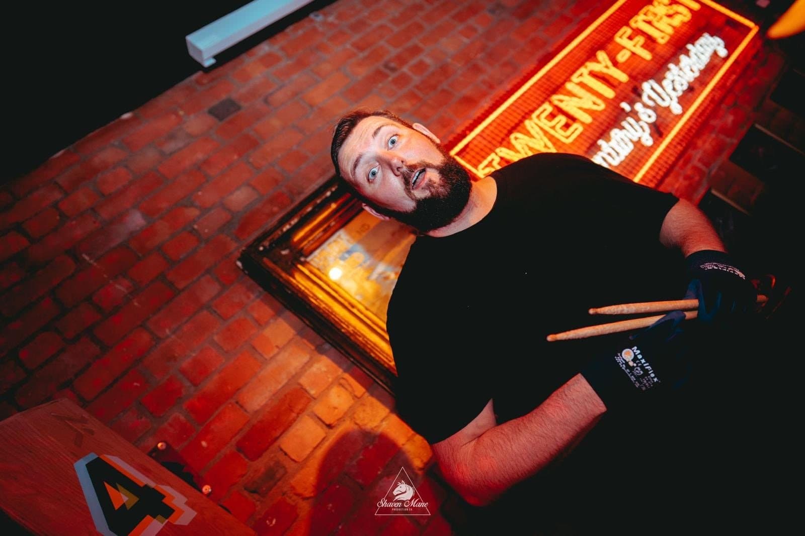 A drummer playing live over a DJ set.